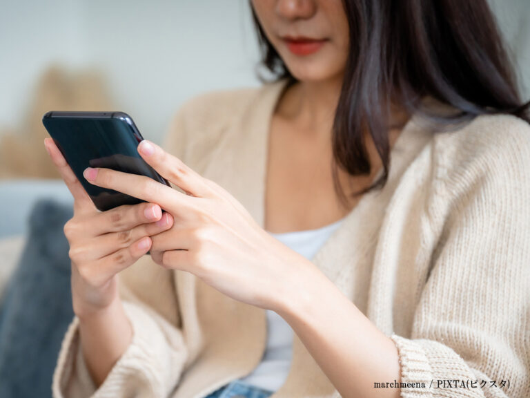スマホを見る女性の画像