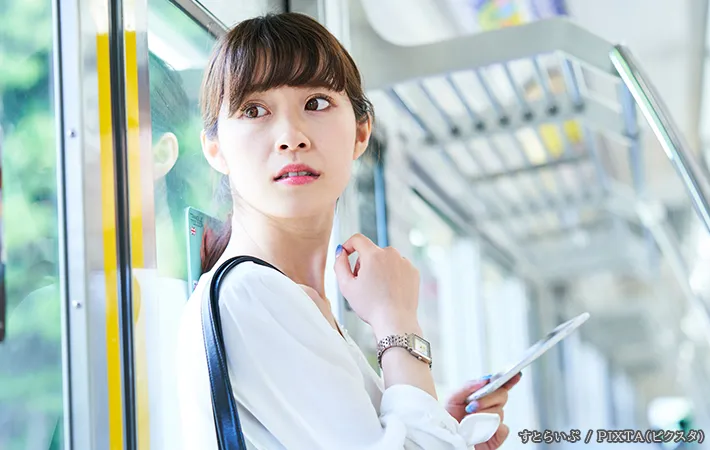 背後を気にする女性の写真