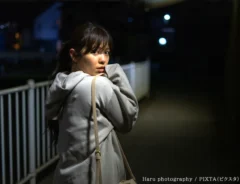 背後を気にする女性の写真