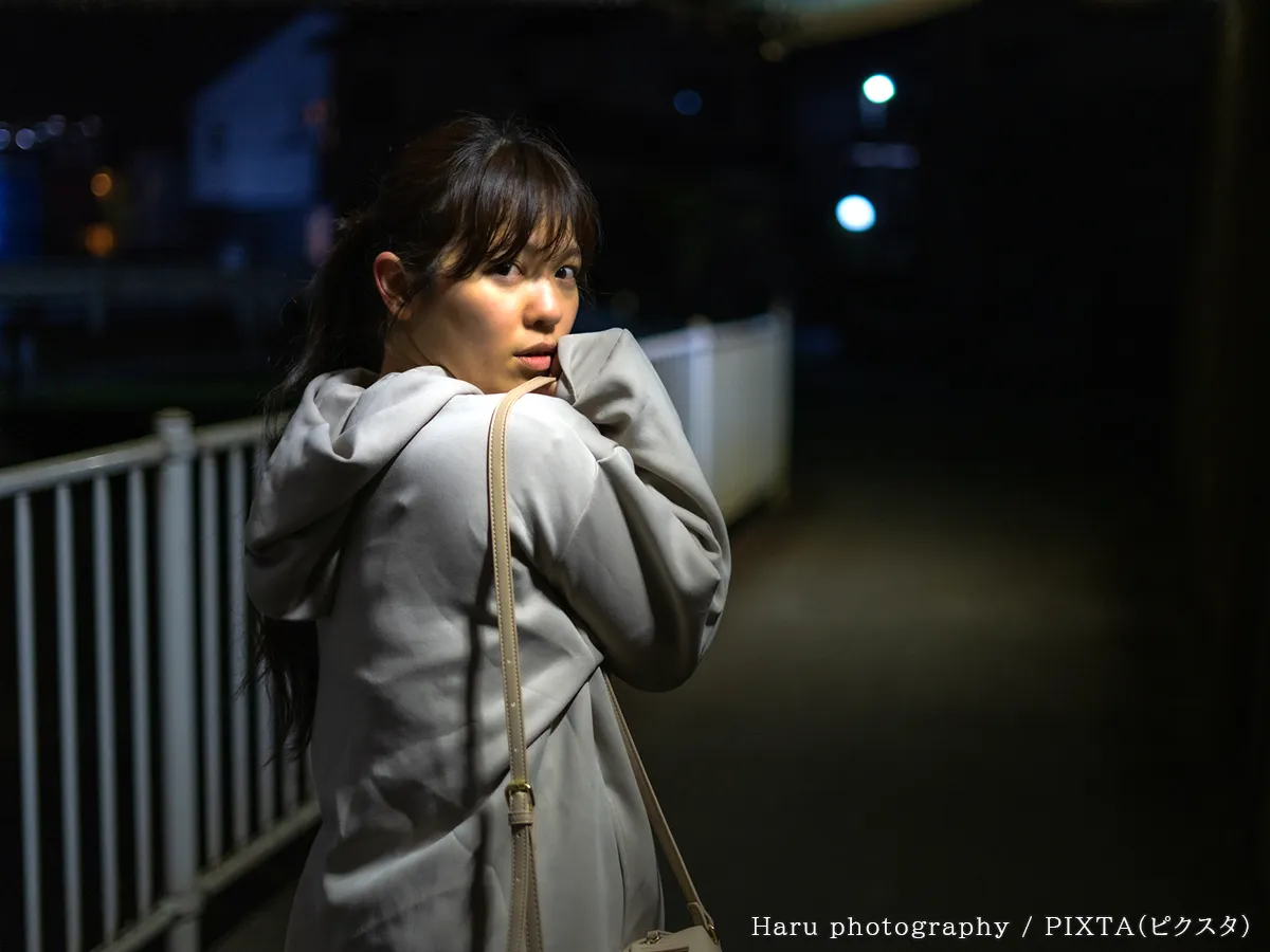 背後を気にする女性の写真