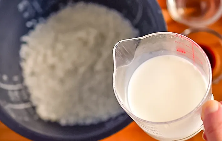 米に牛乳を入れる写真（撮影：小泉明代）