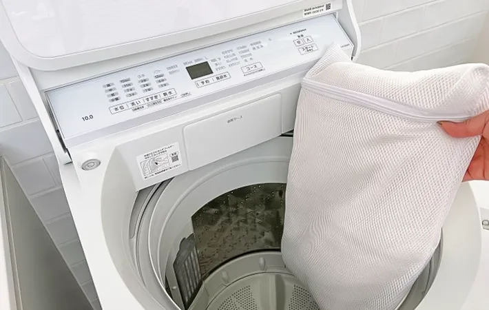 洗濯機に服を入れる写真（撮影：Heulie）