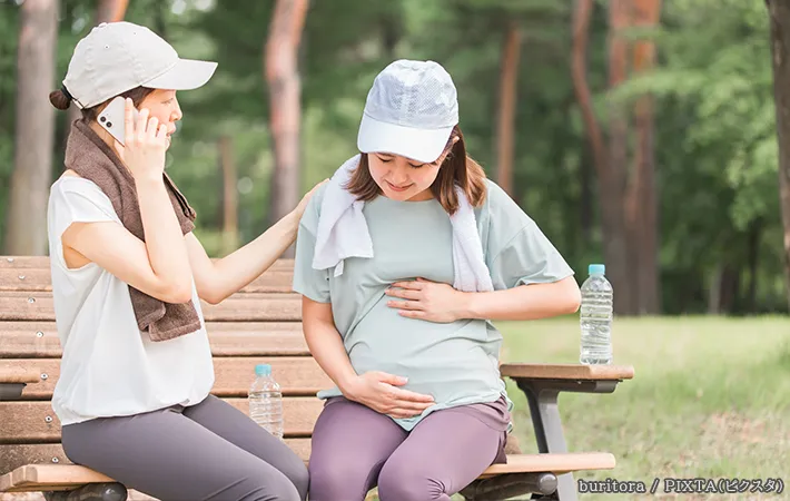 妊婦と電話をしている女性