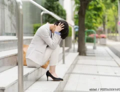 頭をおさえる女性の写真