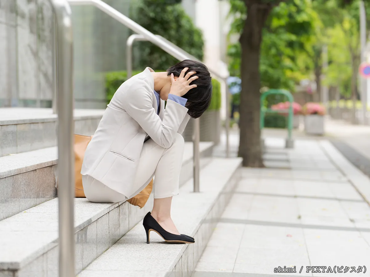 頭をおさえる女性の写真