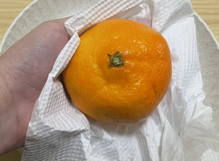 ミカンを拭く写真（撮影：grape編集部）