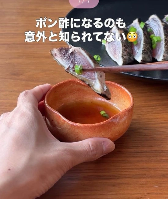 カツオのたたきにポン酢をつける様子