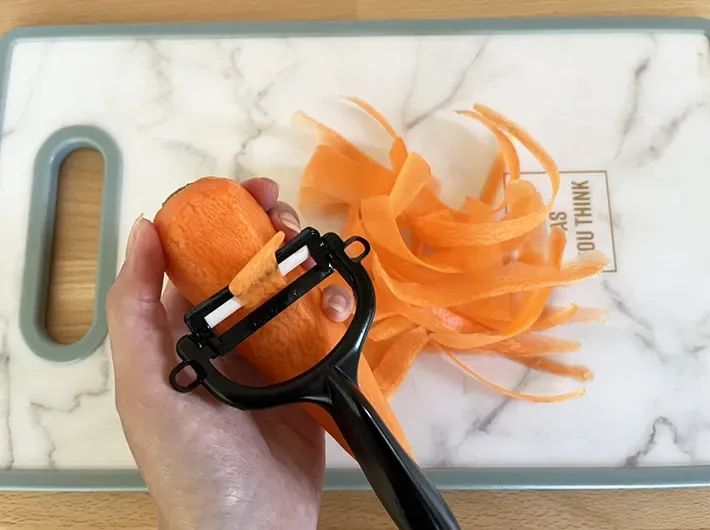 ピーラーで削っているニンジンの写真（撮影：grape編集部）