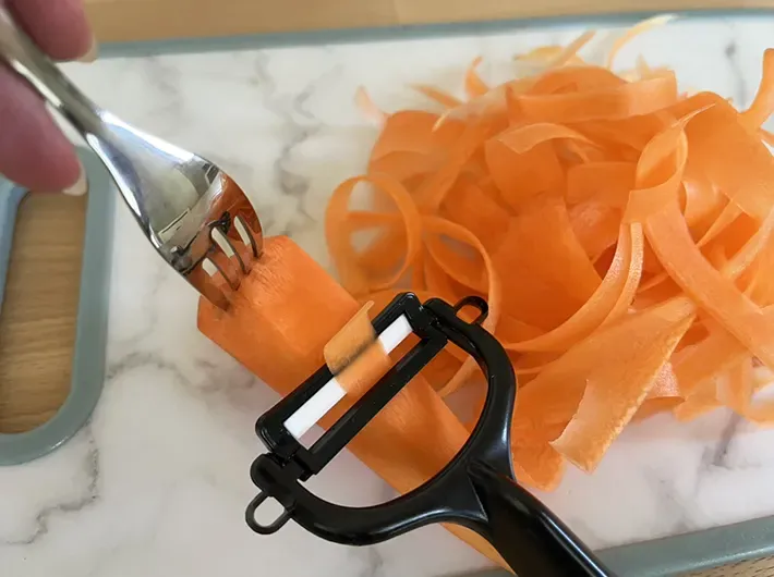 ピーラーで削っているニンジンの写真（撮影：grape編集部）
