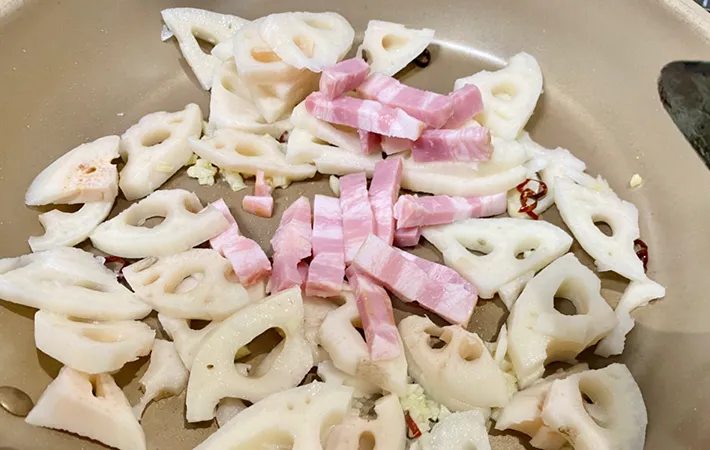 レンコンとベーコンをフライパンに投入した写真（撮影：エニママ）