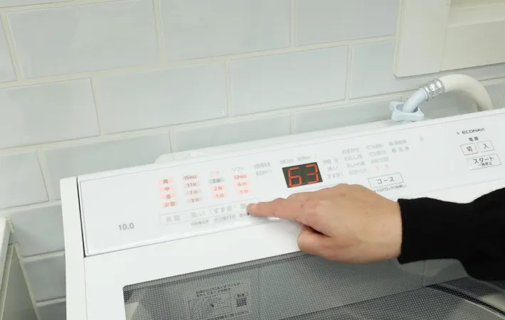 『洗濯機のボタンを押す』写真（撮影：Heulie）