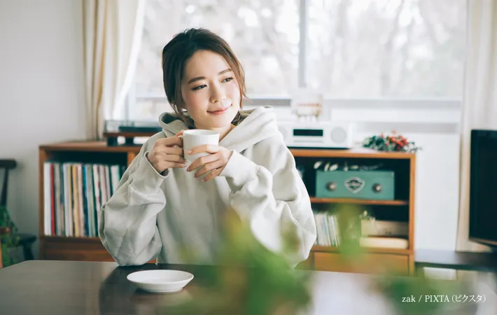『部屋でコーヒーを飲む女性』の写真