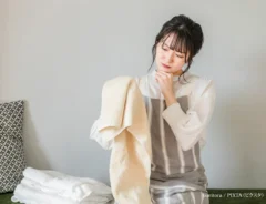 『洗濯物の仕上がりに悩む主婦の女性』の写真