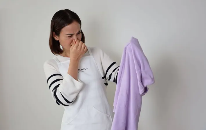 『衣類のニオイで鼻をつまむ女性』の写真（撮影：Heulie）