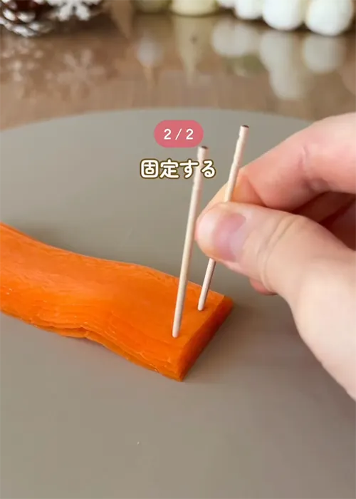 爪楊枝をさしたニンジンの写真