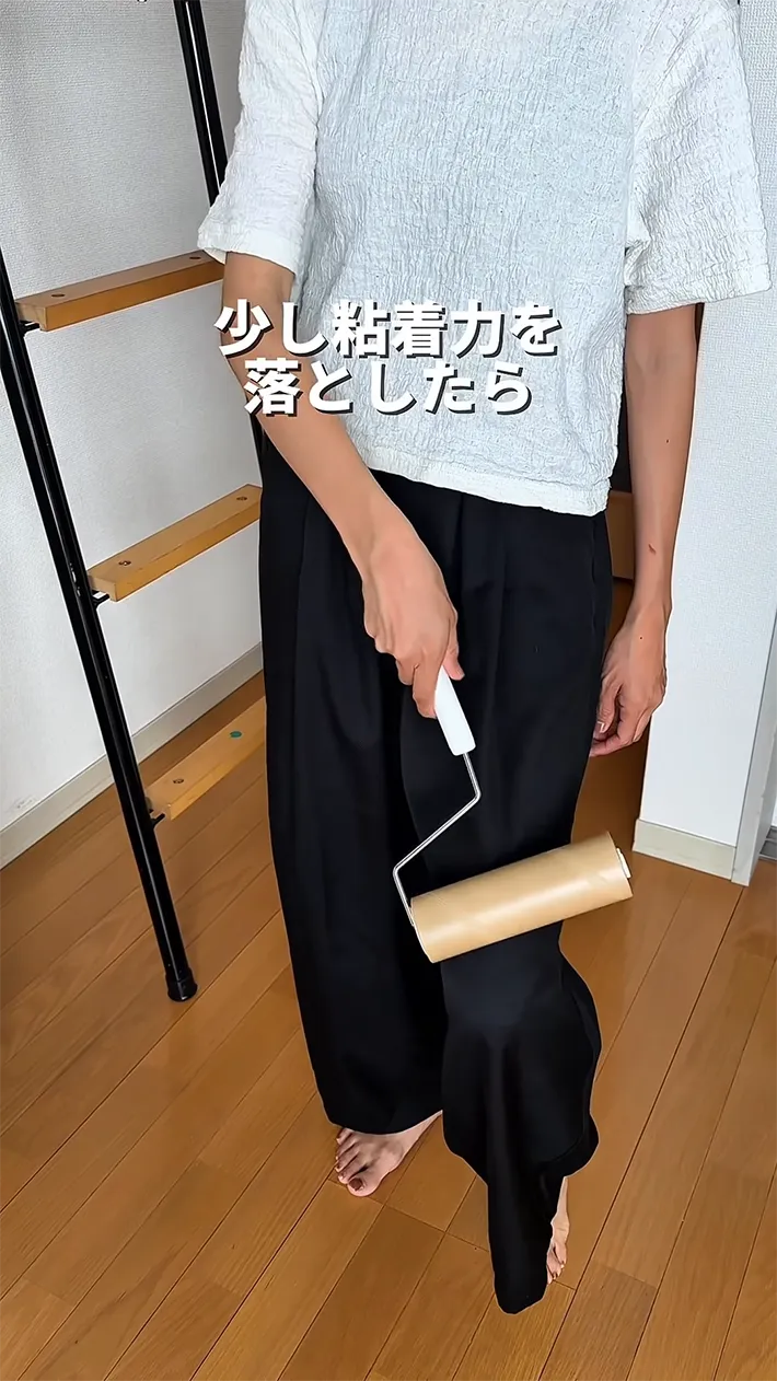 粘着カーペットクリーナーを使う男性の写真