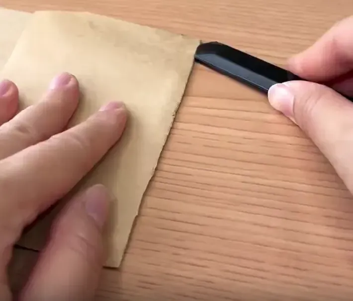茶封筒の折り目をカッターナイフで切る