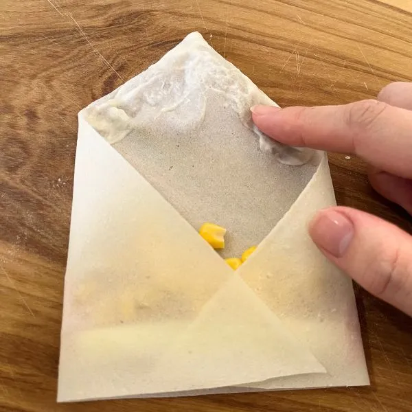 皮の先端に水溶き薄力粉を塗っている写真