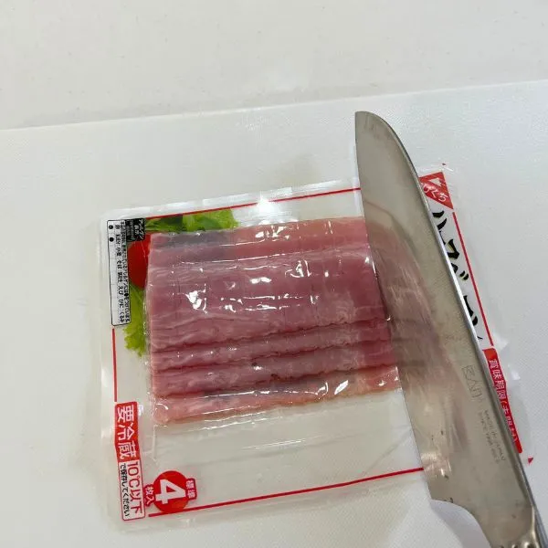 ベーコンをパックの上からカットしている写真（撮影：grape編集部）
