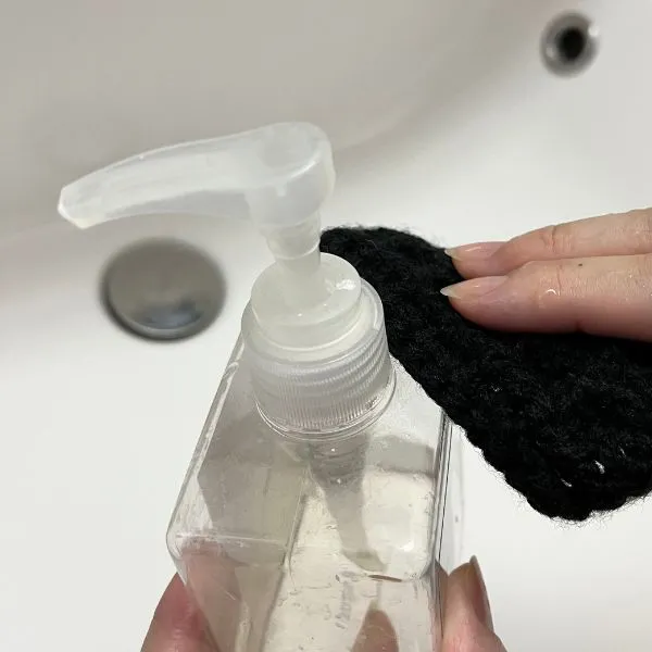 アクリルたわしでハンドソープ容器を掃除している写真（撮影：grape編集部）