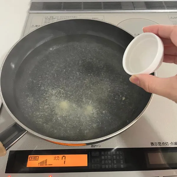 沸騰したお湯に料理酒とショウガを加えている様子（撮影：grape編集部）
