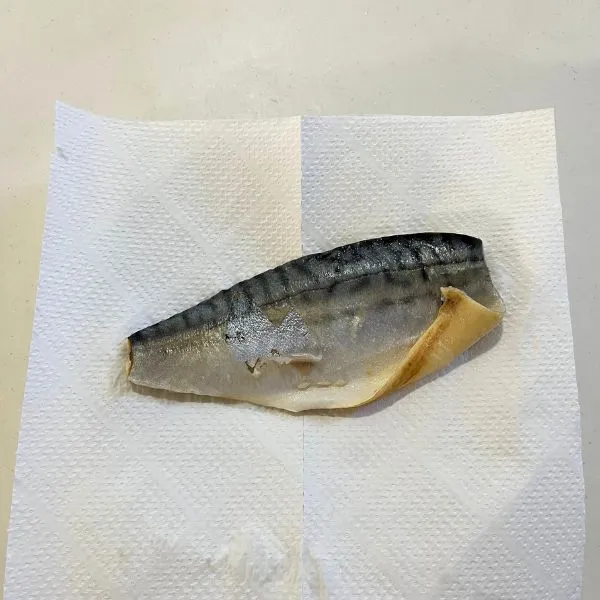 キッチンペーパーでサバの水気を拭き取っている様子（撮影：grape編集部）