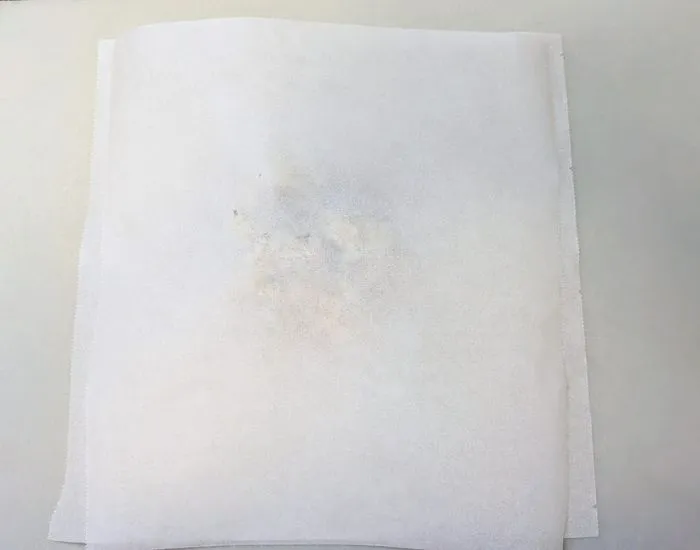 クッキングシートの上にある混ぜごはんの上にクッキングシートを重ねている様子（撮影：grape編集部）