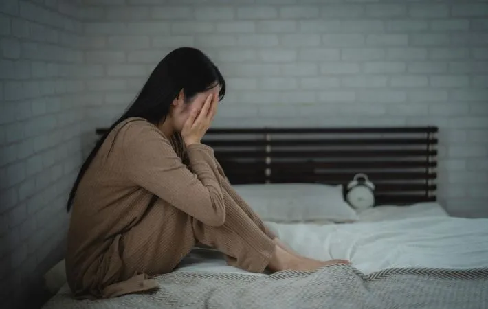 薄暗い寝室にいる女性の写真