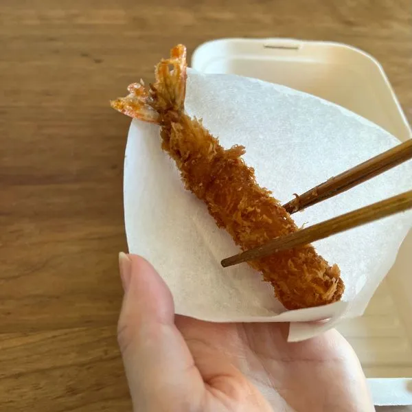 コーヒーフィルターで作ったカップにエビフライを入れている様子（撮影：grape編集部）