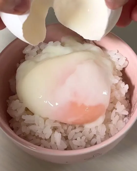 ご飯の上に温泉卵をのせている様子
