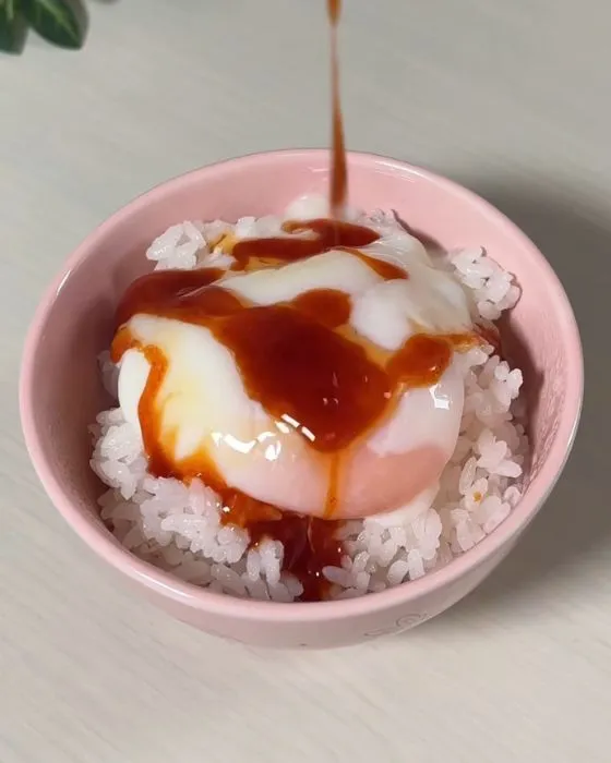 温泉卵に調味料をかけている様子