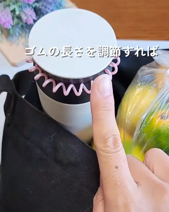 ゴムに水筒を通している様子