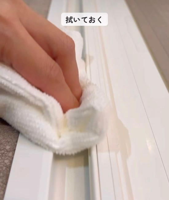 脱衣所側のドアレールを拭き上げる様子