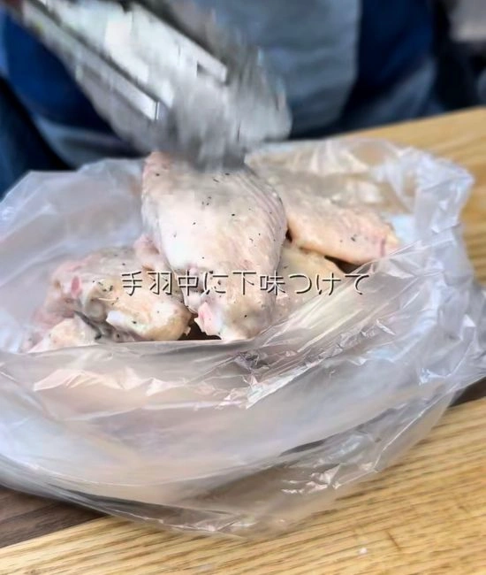 手羽先に粉をつける様子