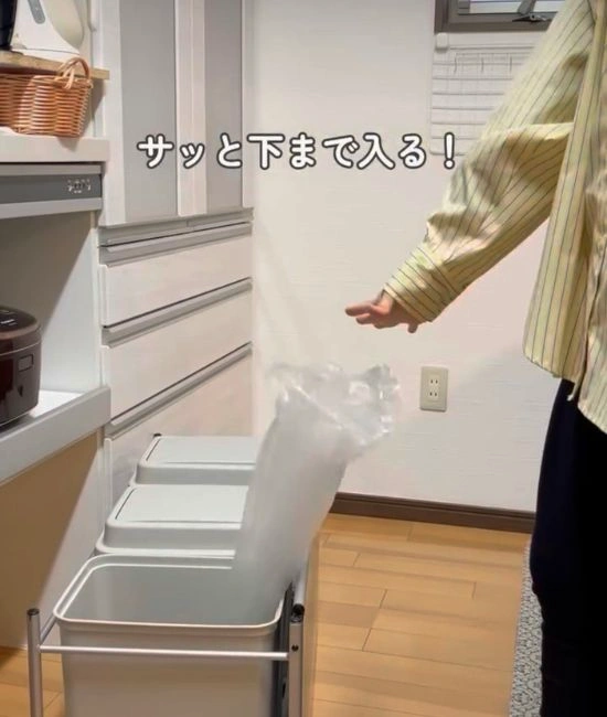 ゴミ箱にゴミ袋を投げ入れる様子