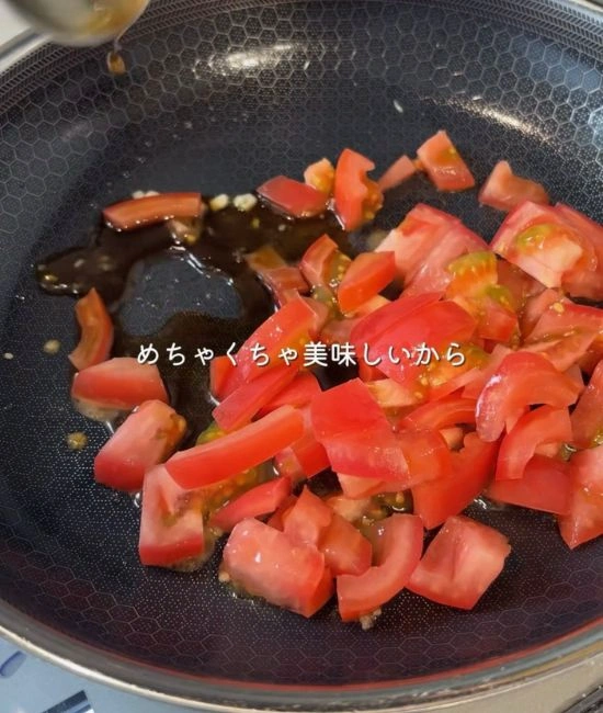 トマトをフライパンに入れる様子