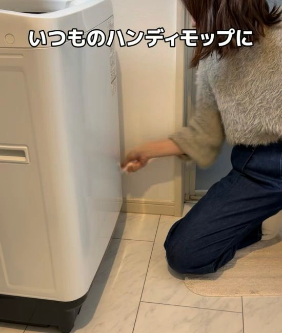 洗濯機のすき間を掃除する様子