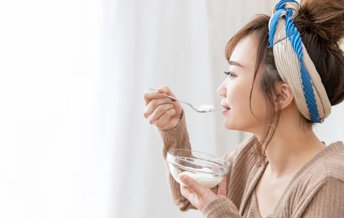 ヨーグルトを食べる女性の写真