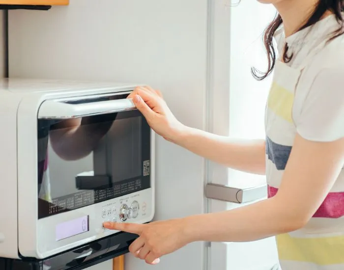 電子レンジのボタンを押そうとしている様子