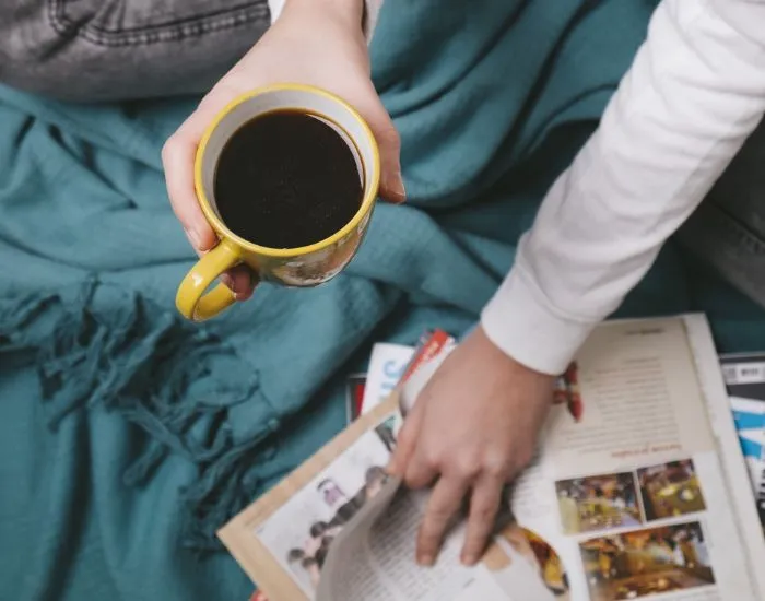 コーヒーを飲みながら雑誌を読んでいる様子