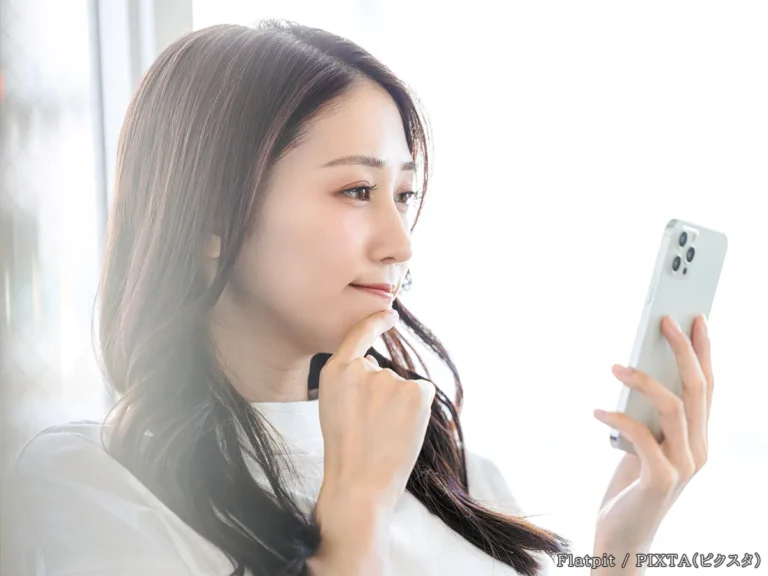 スマホを見る女性の写真