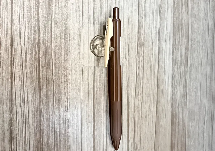 『貼ってはがせるフィルムフック歯ブラシホルダー』とペンの写真（撮影：キジカク）