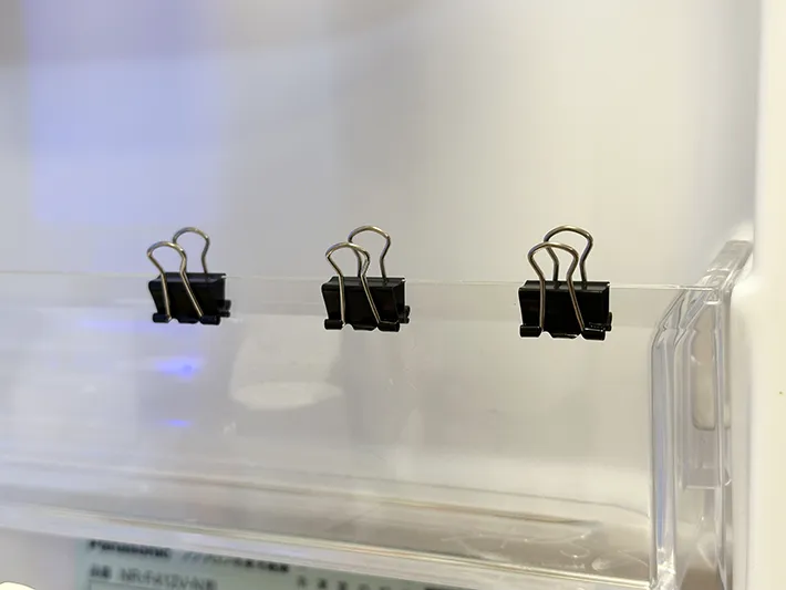 冷蔵庫のドアポケットに15mm幅のダブルクリップを挟んだ画像（撮影：grapeライフハック編集部）