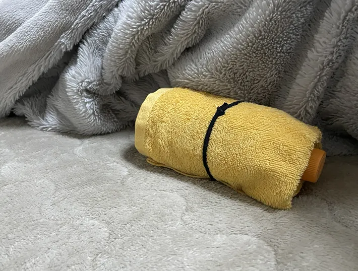 ペットボトルの湯たんぽを布団に入れる写真（撮影：grape芸能編集部）