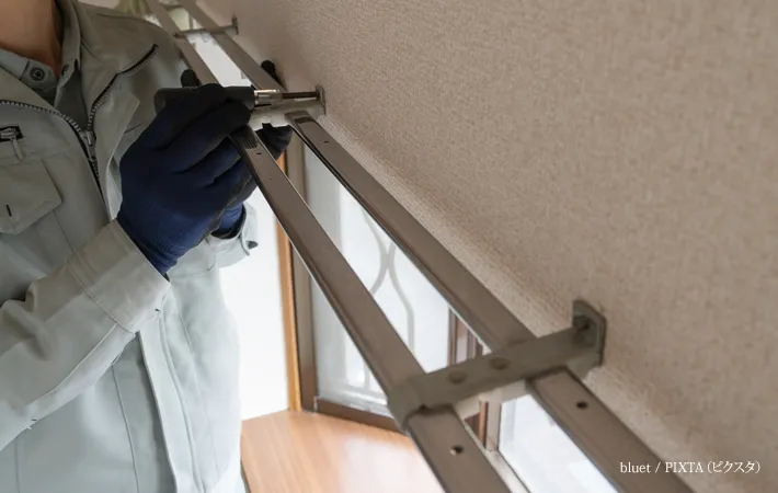 『カーテンレールの設置をする作業員イメージ』の写真