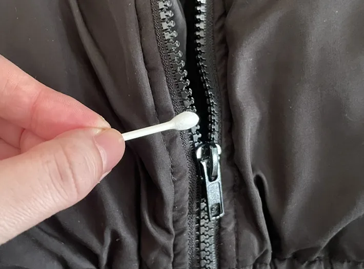 ファスナーに綿棒でリップクリームを塗る写真（撮影：grapeライフハック編集部）