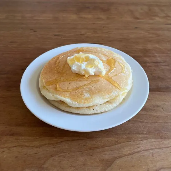 焼き上がったホットケーキにクリームチーズ風とハチミツをのせた写真（撮影：grape編集部）