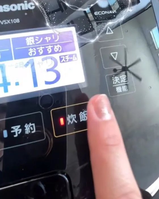 炊飯器のスイッチを押している様子