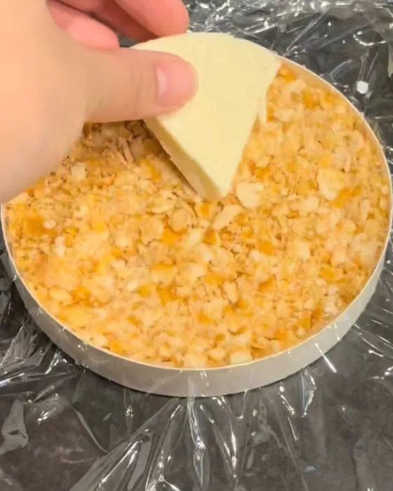 クラッカーの上にポーションチーズをのせている様子