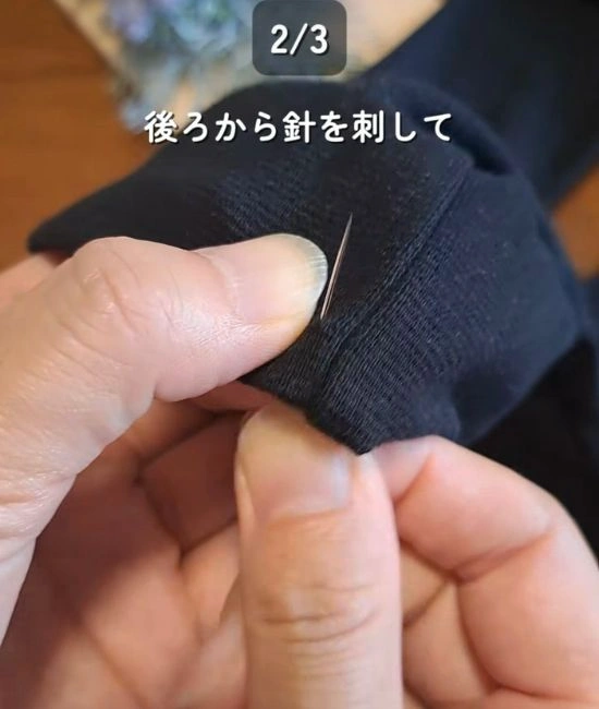 裾に針を通す様子